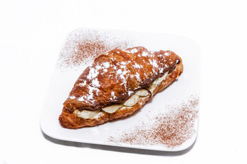 Croissant with chocolate butter and banana isolated on a white background.