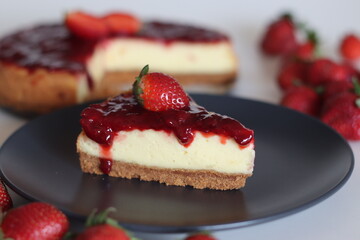 Slice of Strawberry cheese cake. Silky smooth and creamy cheese cake topped with homemade fresh strawberry sauce
