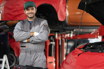 Portrait automobile mechanic man standing and crossing his arms with looking at camera. diagnostic and repairing vehicle at garage automotive, Car care check and fixed and services insurance concept.