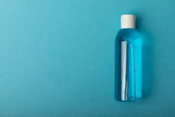 Micellar water . Cleansing the skin of sebum and makeup. Composition on a blue background. Beauty concept. Copy space text. flat lay