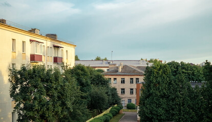 Old Soviet houses in cozy town. Street view landscape old cirty, little houses on sunset. Old Soviet architecture street front view. Calm town street. Calm russiun town street with green trees