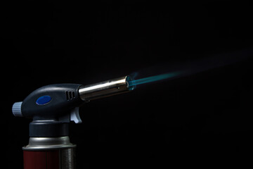 Fire from a gas burner on a black background. Blue fire from a burner