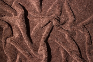 Texture of crumpled brown bath towel. Soft surface as background for your image