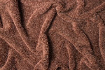 Fototapeta na wymiar Texture of crumpled brown bath towel. Soft surface as background for your image
