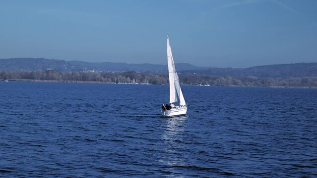 Sailboat turns back on the lake, camera follows