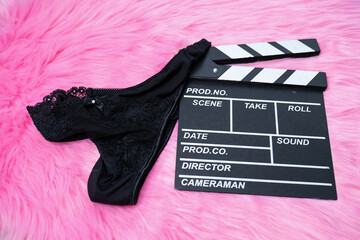 black female underwear lingerie on movie clapper on the floor, pink fur, adult movie filming, video
