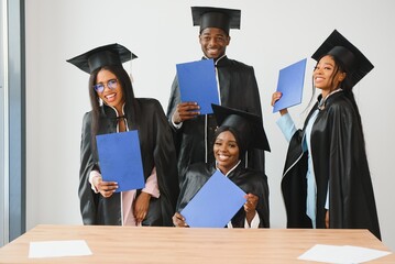 portrait of multiracial graduates holding diploma