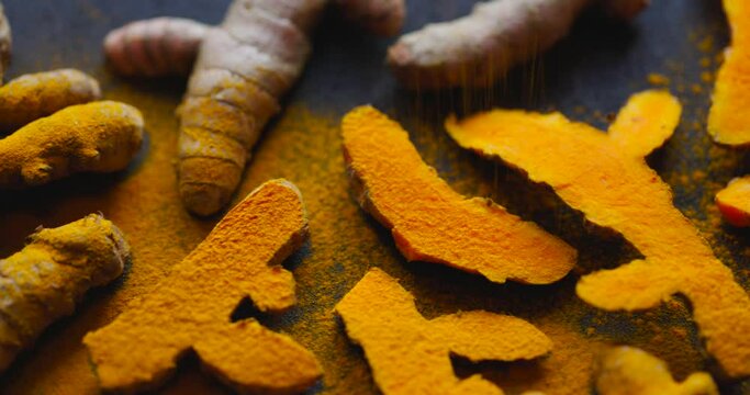 Sprinkling with turmeric powder. Fresh turmeric roots and turmeric powder.