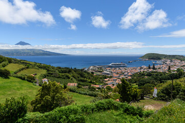 View over Horta to the Pico volcano / View over the town of Horta on the island of Faial, a cruise ship is moored in the harbor, on the horizon you can see the Pico volcano, Azores, Portugal. - 530652433