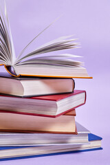 Close-up of a stack of books with one open book on top