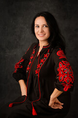 A beautiful Ukrainian woman in a black dress with red embroidery