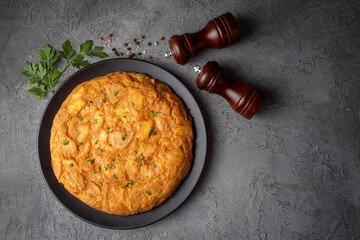 Spanish omelette with potatoes, typical spanish cuisine on gray concrete floor. Tortilla Espanola. Turkish name; Yumurtali patates