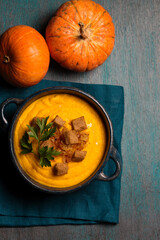 Pumpkin puree with crackers and parsley in a blue bowl
