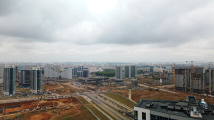 Fototapeta na wymiar Construction site of a new city block. Construction of multi-storey buildings. Overcast weather. Aerial photography.