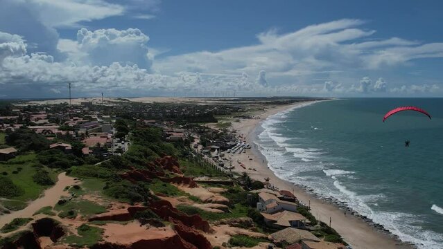 paragliding flight through the mountains, rocks and beach in Morro Branco in Ceará, Brazil