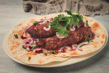 Lula kebab, on lavash, with red onion, pomegranate, and sumac, top view, close-up, horizontal, no people,