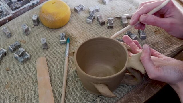 Woman learning color painting her self-made pottery mug. Confidence female relax and enjoy handicraft activity lifestyle hobbies ceramic sculpture painting workshop at pottery studio