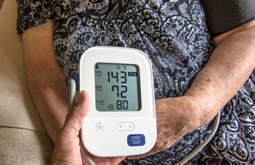 Checking blood pressure with a digital monitor.
Senior Caucasian woman checking her blood pressure at home with a digital blood pressure monitor.
