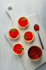 Tartlets with red caviar, on a light background, close-up, top view, no people,