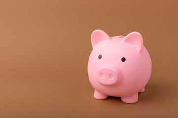 Piggy bank on brown texture background. Close-up. Space for copy. Flat lay. Savings and accumulation concept.