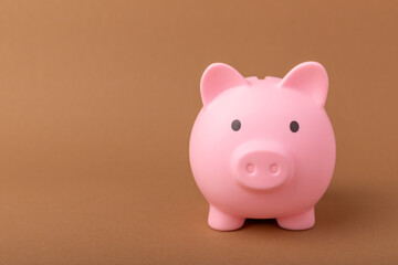 Piggy bank on brown texture background. Close-up. Space for copy. Flat lay. Savings and accumulation concept.