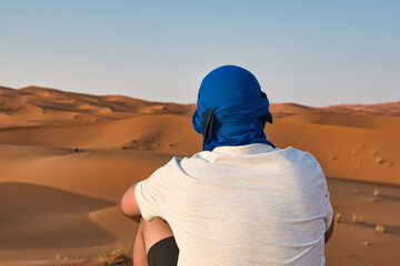 man in the Sahara desert near the village of Merzouga - obrazy, fototapety, plakaty