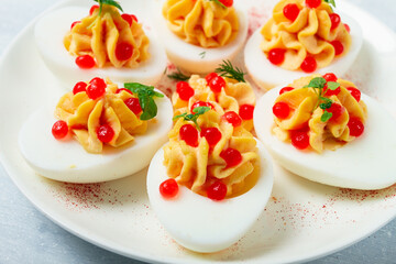 Stuffed eggs, with red caviar, micro greenery, Snack, on a white plate, top view, close-up, no people,