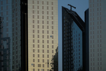 Close-up of modern glass buildings. Facade is reflective, not transparent. Minimalist architecture and design ideal for urban city backgrounds and horizontal copy space.