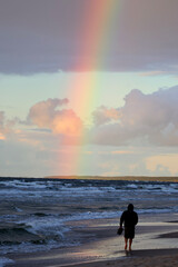 Kolorowa tęcza w czasie deszczu nad horyzontem morza. 
