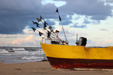 Żółty statek na plaży podczas zachodu słońca. 