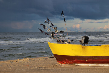 Żółty statek na plaży podczas zachodu słońca. 