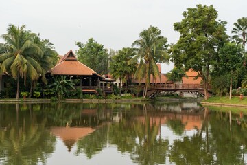 Beautiful shot of pavilions and tropical trees reflecting in the pond