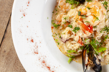 mariscos y pescados en plato blanco sobre fondo de madera