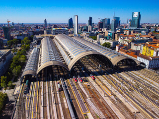 Aerial view of the station where trains arrive. An old arched structure made of metal and glass...