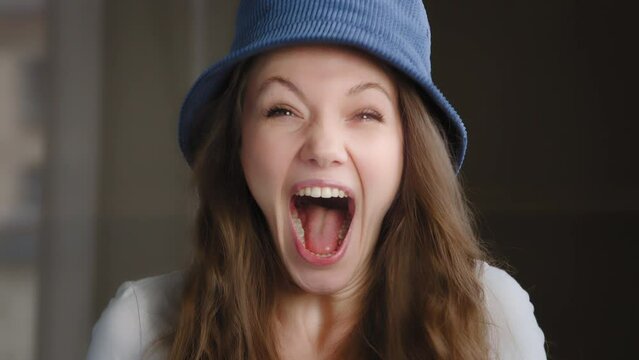 Portrait young attractive funny cute caucasian woman in hat looking at camera contented excited surprised emotional girl screaming with happiness shocked good news winning celebrating victory rejoices