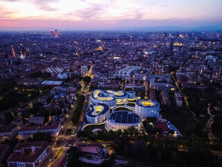 Aerial view of solar panels on the roof. The new campus of the SDA Bocconi School of Management is a modern building with classrooms. Colorful sky at sunset. Ecological energy. Milan Italy 09:2022
