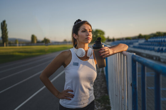 One woman stand at stadium with supplement water bottle take a brake © Miljan Živković