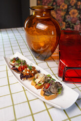 assorted bruschetta on a white plate on the table