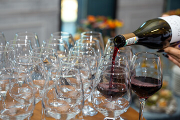 bottling red wine from a bottle by glasses close-up