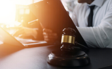 Male lawyer working with contract papers and wooden gavel on tabel in courtroom. justice and law...