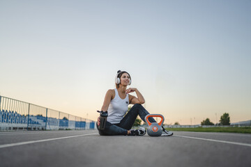 one caucasian woman female athlete rest hold supplement shaker kettlebell girya weight while...