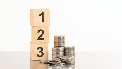 wooden cubes with the numbers 123 and coins on table. business and finance concept