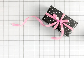 2023 New Year b&w minimal concept with polka dot wrapping paper gift box with pink ribbon bow on...