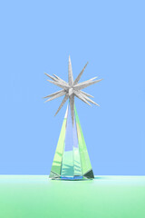 Minimal futuristic Happy New 2023 year concept. Shiny cristal glass prism with a silver glitter star ornament on green blue background. Surreal christmas tree idea. Pastel holiday winter aesthetic.