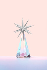 Minimal futuristic Happy New 2023 year concept. Shiny crystal glass prism with a silver star ornament on orange background. Surreal Christmas tree idea. Pastel holiday aesthetic.