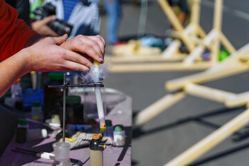 Hands pour powder from the test tube into another test tube with the release of smoke