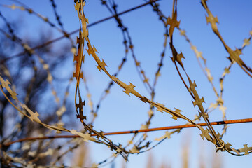 Steel barbed wire on the fence for security at the security facility. Protection against penetration into forbidden territory