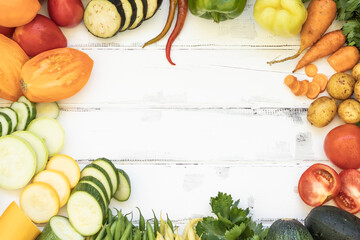 various vegetables on a wooden white background Zucchini Tomatoes Cucumbers Carrots Potatoes String beans Healthy food Copy space