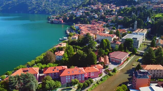 Aerial view of Lake Como. city ​​center. A local ferry arrives in the city. Bell tower. Tourism and romance. Mountains around the lake. Red roofs. Green Planet. Sailing yacht. Italy, Bellano, 09.2022