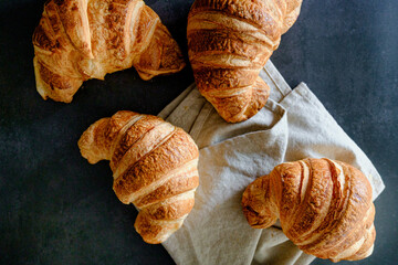 Delicious breakfast with delicious and fresh croissants on a dark concrete background. Top view. 